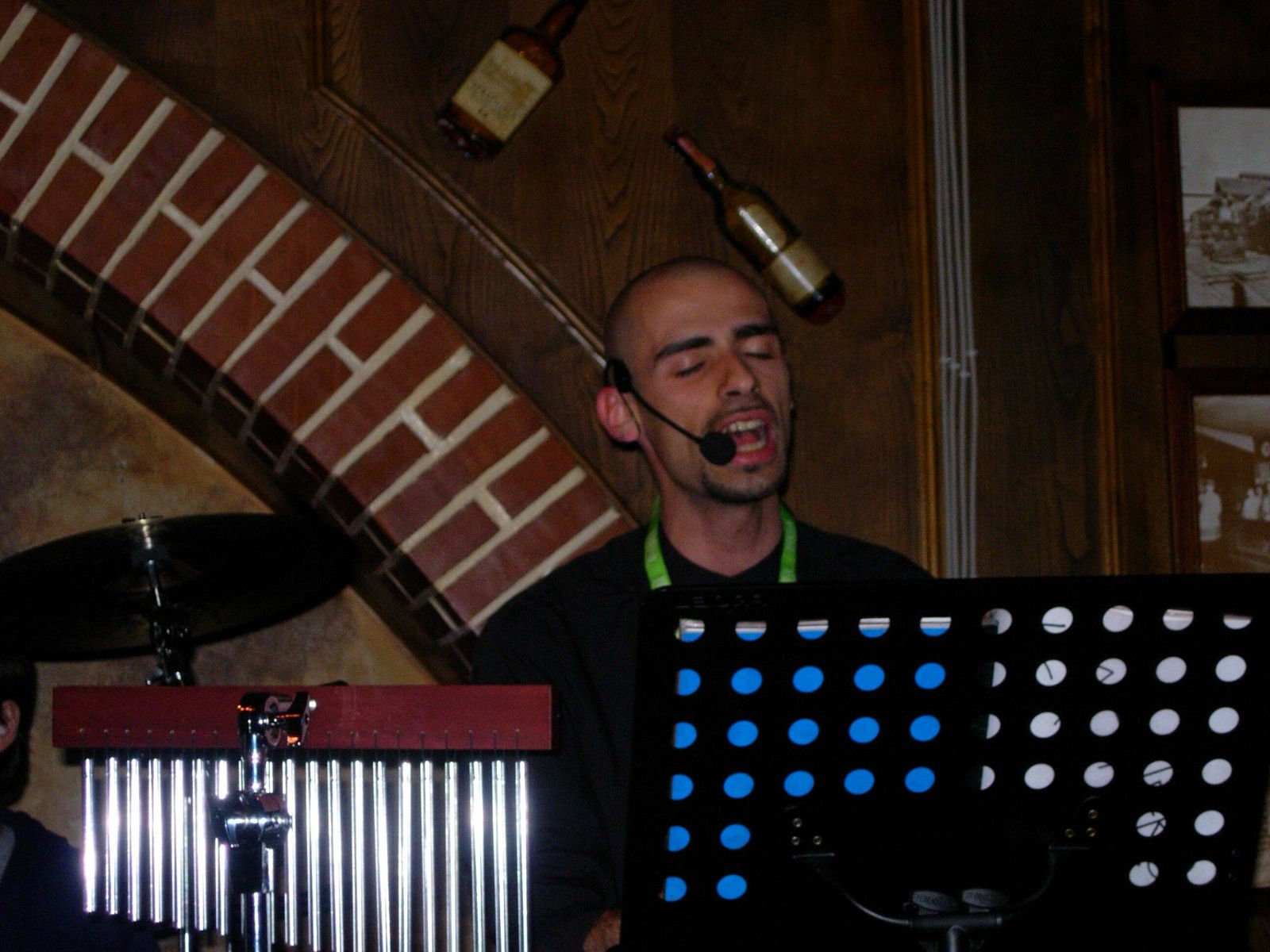 Mirko Labinero canta con microfono ad archetto, accanto ai campanelli a percussione